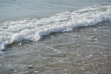 Fototapeta premium sea waves rolling on sandy beach – close-up shoreline sea waves gently rolling onto the sandy beach. clear water, foam, and soft motion create a calming natural seascape. ideal for vacation 