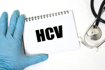 HCV in notebook isolated on bright white background. doctor's hand and stethoscope.