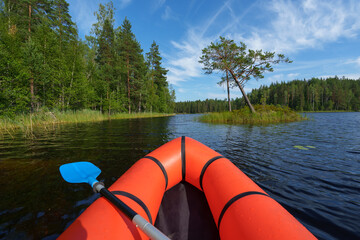 Orange packraft on a beautiful summer lake.