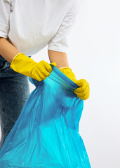 A woman with a blue trash bag poses on a white background