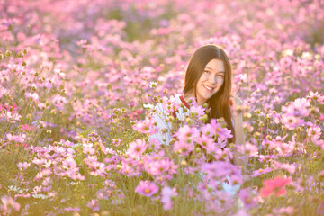 Fototapeta premium Asian cute young woman joyful, smiling with flowers garden background.