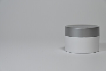 Minimal white cosmetic cream jar with gray lid