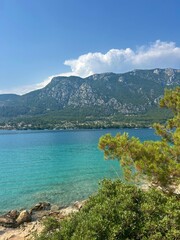 The beautiful blue waters of the Mediterranean Sea surrounded by mountains and trees 