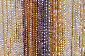 Colorful strands of pearls in various shades displayed in an elegant arrangement for jewelry design