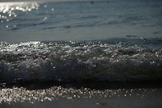sea shore with wave breaking on the beach gentle sea wave breaking on a sandy shoreline. peaceful coastal scene with soft water movement and natural textures. perfect for themes of relaxation - Powered by Adobe
