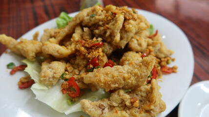 close up of Cantonese dish deep fried Bombay Duck fish with Spicy Salt on a white plate