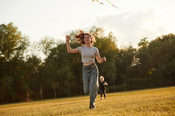 Sister and her little brother, with kite. Two kids are having fun on the summer field