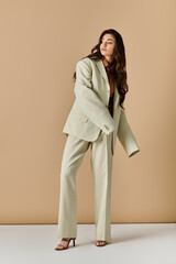 Stylish young woman showcases elegant suit and tie look in studio setting