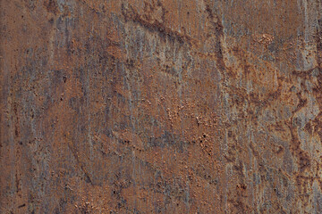 Close-up of a textured rusty metal surface with shades of brown and orange. The surface shows signs...