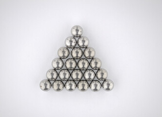 Steel balls from a car bearing arranged in an equilateral triangle on a white background