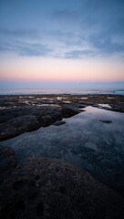 Fototapeta premium Serene coastal landscape at twilight with calm water and colorful sky