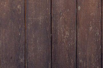Close-up of a rustic wooden surface with dark brown planks. The texture shows natural grain...