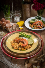 Pad Thai Pad Thai with rice vermicelli and shrimp with ingredients placed on the table.