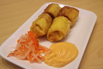 Golden Crispy Fried Rolls with Tangy Pickled Vegetables and Creamy Dipping Sauce