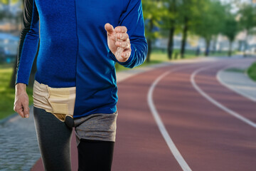 Young man wearing inguinal hernia bandage after injury during running workout training. Half in hernia belt and underwear, half in athletic shorts and shirt, fitness background