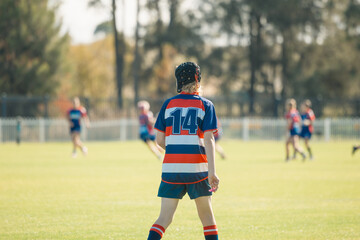 Junior rugby union player on field wearing protective head gear