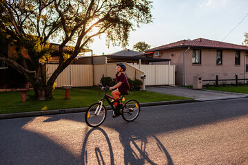 Pre-teen boy trick riding with only one hand on suburban street in Australian country town