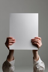 Blank white paper held aloft by hands (2)