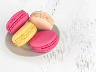 colorful macaroons on white wooden table with copy space