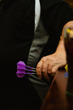 Guy holding 3 darts