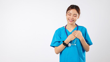 Smiling healthcare woman doctor, asian nurse, with stethoscope on chest, places hands on heart, in...