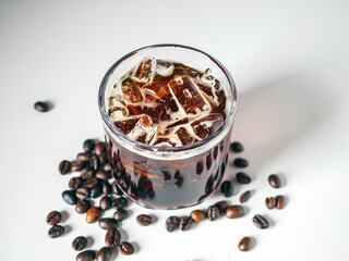 Iced black coffee, iced Americano coffee in glass and roasted coffee beans on white background.