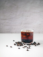 Iced black coffee, iced Americano coffee in glass and roasted coffee beans on white background.