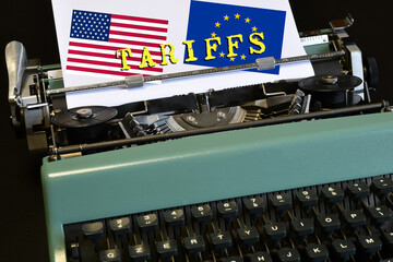 "Tariffs" written with the US and EU flags on a vintage typewriter. A concept for new customs tariffs.