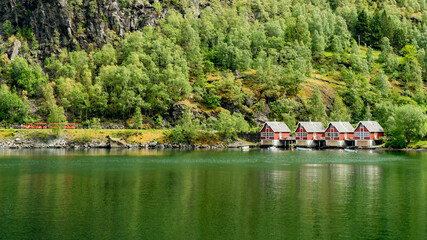 Red boathouses by the Flam fjord with the Flam railway in the background