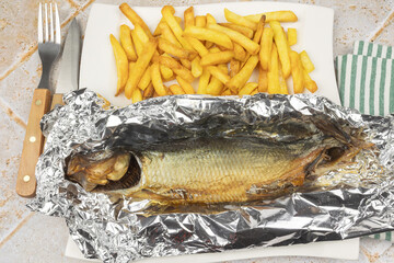 hareng fumé et frites dans une assiette