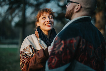 A candid moment capturing two friends sharing a joyful and warm conversation outdoors in autumn.