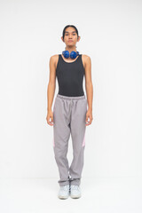 A composed Young Asian Transwoman standing still with hands by her sides, headphones on neck....