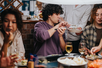 A group of friends enjoying a cozy dinner gathering, sharing food, and engaging in conversation, creating a warm and inviting atmosphere.