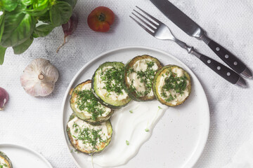 Appetizing Fried zucchini with garlic sauce in a white plate