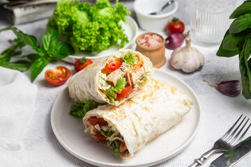 Appetizing Shawarma with chicken and fresh vegetables on a light background