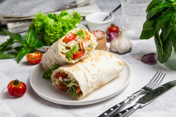 Appetizing Shawarma with chicken and fresh vegetables on a light background
