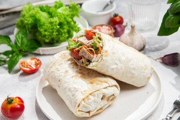 Appetizing Shawarma with chicken and fresh vegetables on a light background