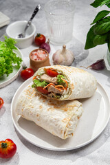 Appetizing Shawarma with chicken and fresh vegetables on a light background