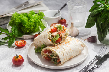 Appetizing Shawarma with chicken and fresh vegetables on a light background