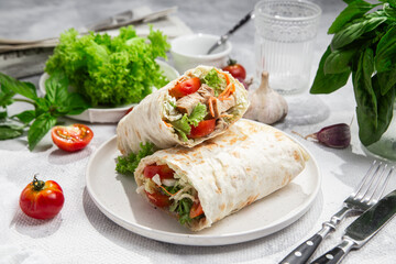 Appetizing Shawarma with chicken and fresh vegetables on a light background