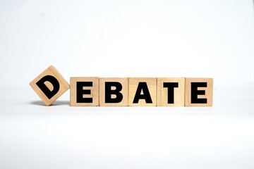 DEBATE writing on a wooden block. Bright white background.