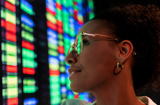 Close-up of female scientist analysing dna sequencing in front of colorful led screen