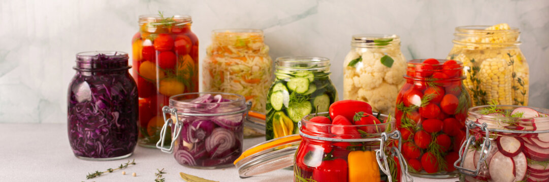 Fresh vegetables like cabbage, tomatoes, cucumbers and radishes, onions, corn, peppers and cauliflower, fermenting naturally to boost health and preserve nutrients, banner
