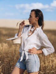 Close-up view to young Woman in a Wheat Field on a Sunny Summer Day