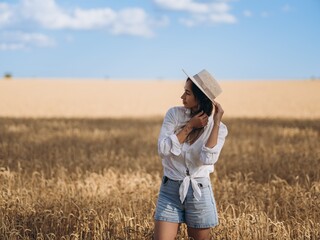 Young Woman in a Wheat Field on a Sunny Summer Day
