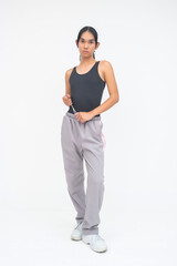 A confident Young Asian Transwoman casually playing with her waistband laces. Isolated on a white background.