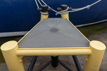 Metal Platform Docked by a Ship with Ropes and Bollards
