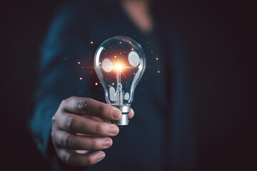 Businessman holding illuminated lightbulb, idea, innovation and inspiration with glowing, smart intelligent creativity with bulbs, Motivation and innovation concept