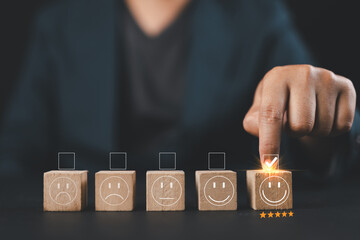 Customer services, the best excellent business rating experience. Satisfaction survey concept. The hand of a businessman chooses a smiley face on a wood block cube. 5 Star Satisfaction.