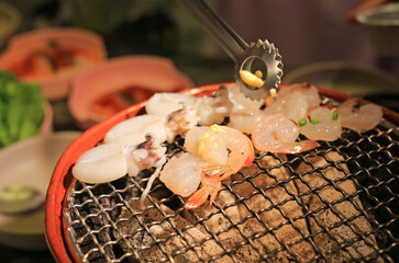 Squid, shrimp and vegetables grilling on grille, Fresh barbeque seafood in restaurant.